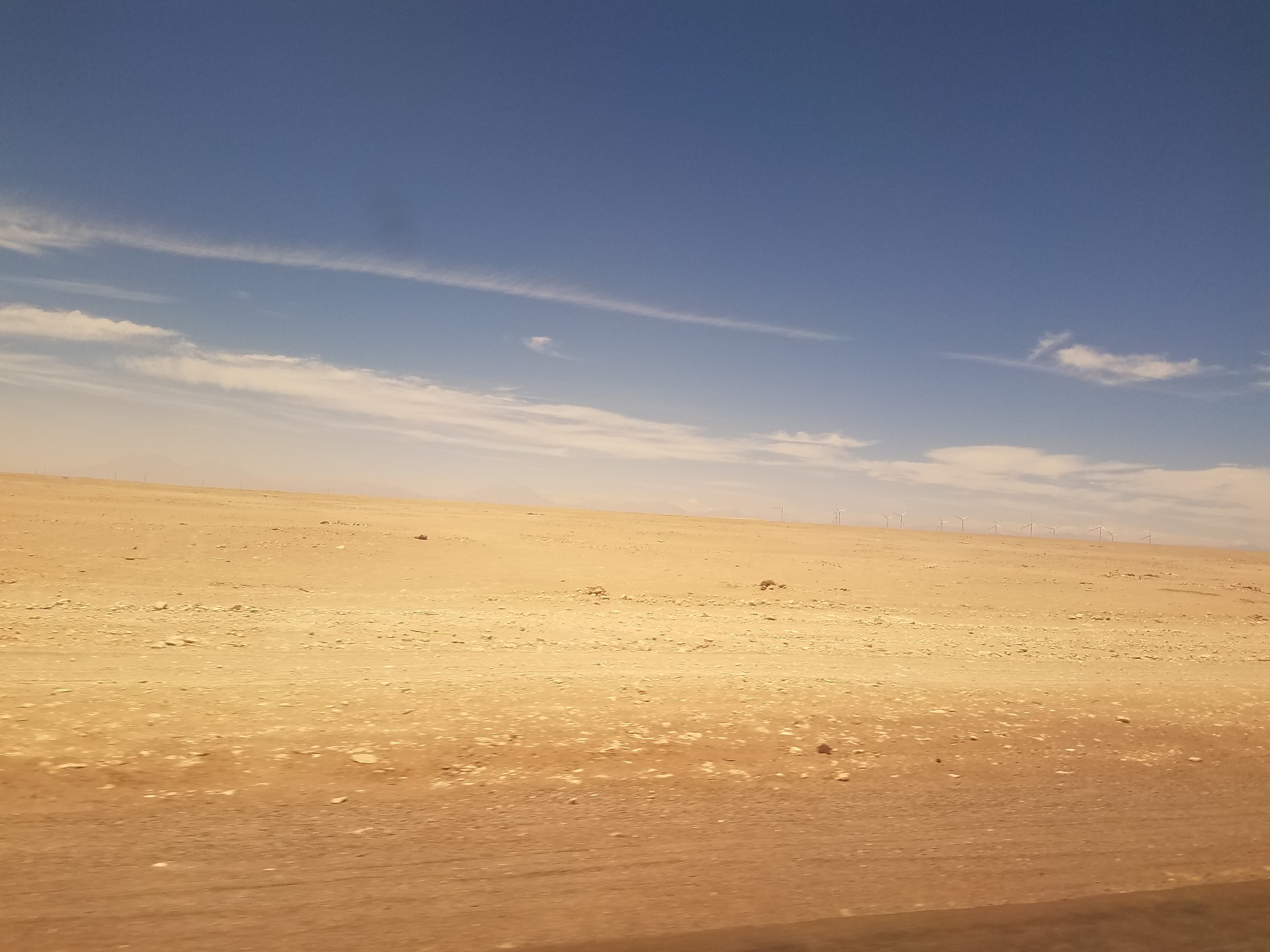 View of the desert with some distant windmills and mountains